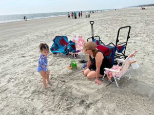 Family enjoying Hilton Head Island beach with Shibumi Shade, Cool Cabana, beach chairs, and wagons from Getaway Gear Rentals